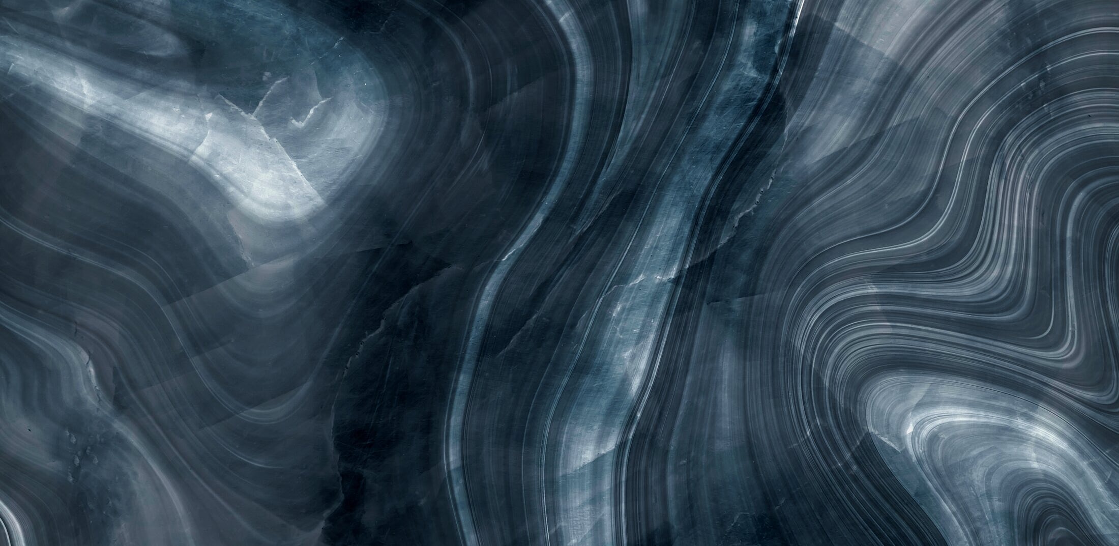 Abstract dark marble texture with wavy patterns.